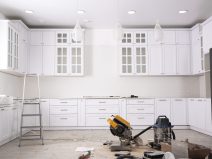 Renovated kitchen interior with stylish furniture, refrigerator and maintenance equipment