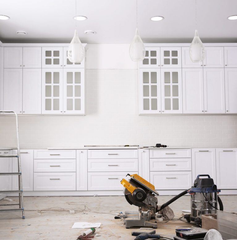 Renovated kitchen interior with stylish furniture, refrigerator and maintenance equipment