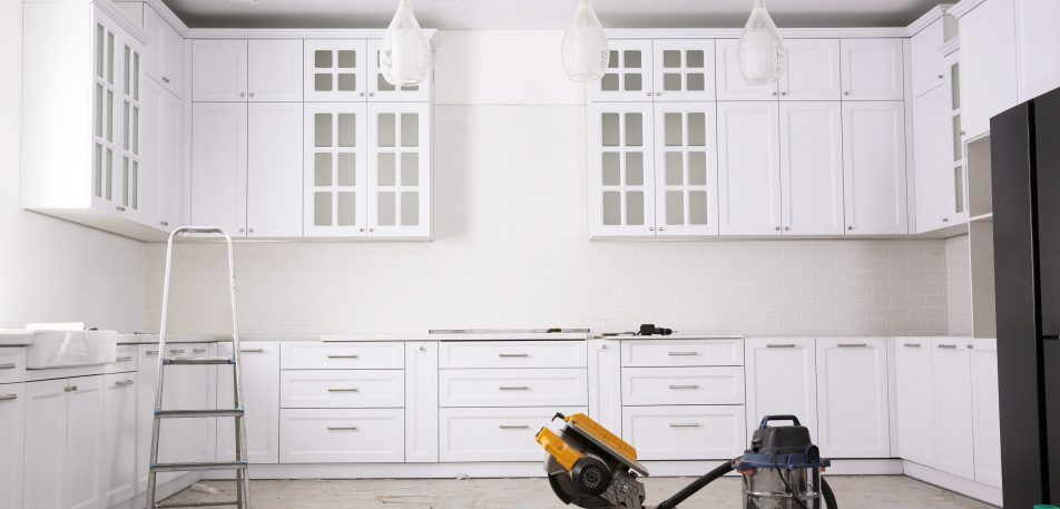 Renovated kitchen interior with stylish furniture, refrigerator and maintenance equipment